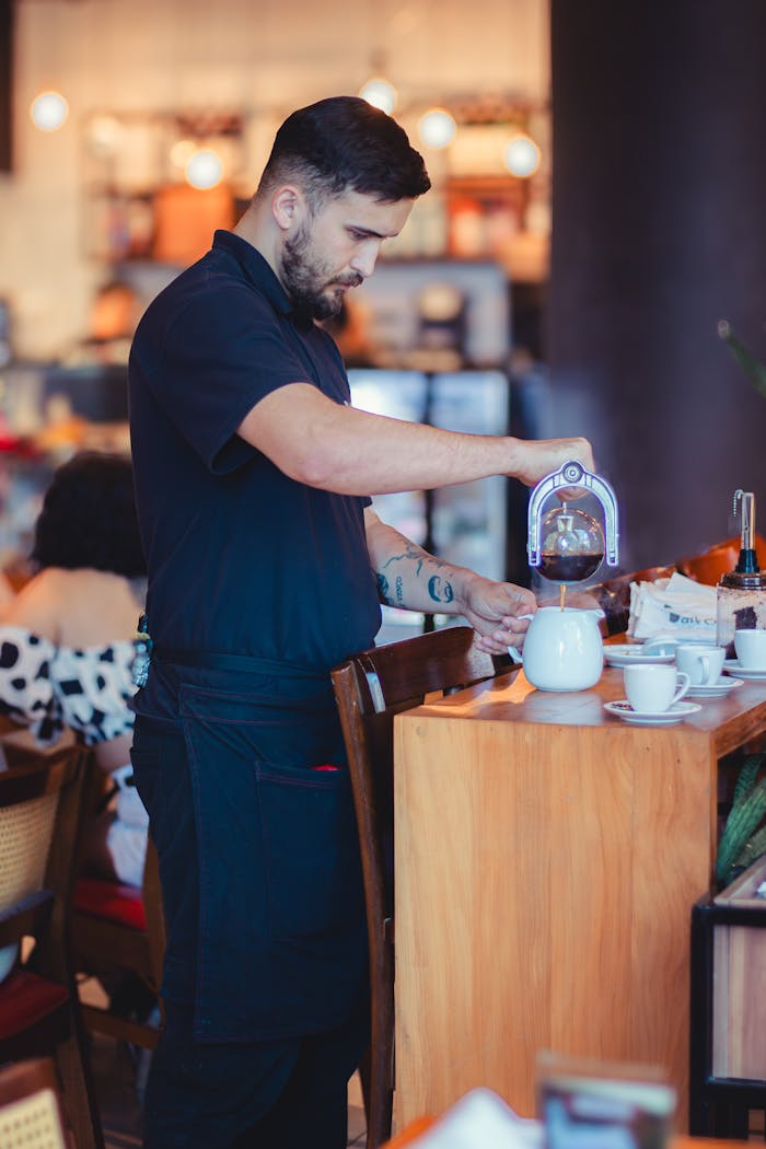 A barista expertly pours coffee in a modern café setting, highlighting coffee culture.