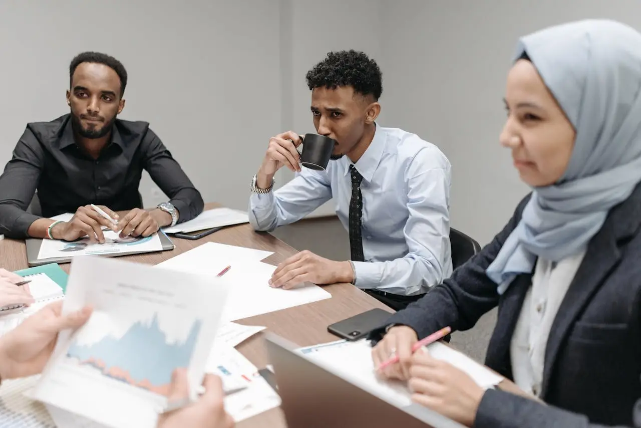 A multicultural team engaged in discussion during an office meeting, highlighting diversity and teamwork.