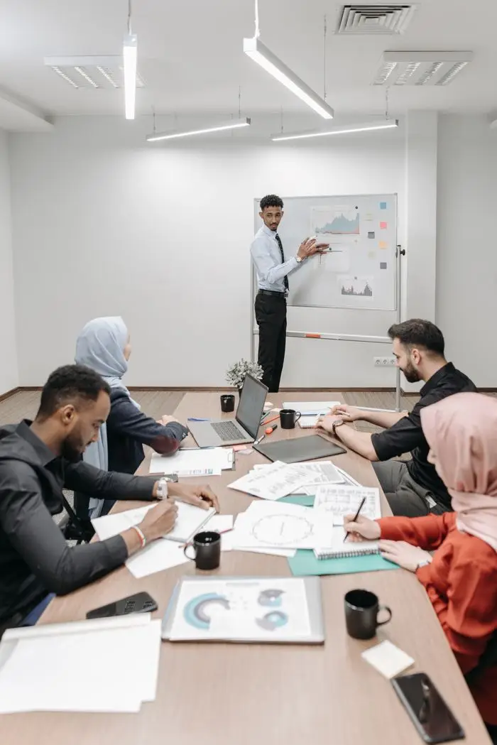 A multicultural team engaged in a presentation in a modern office setting.