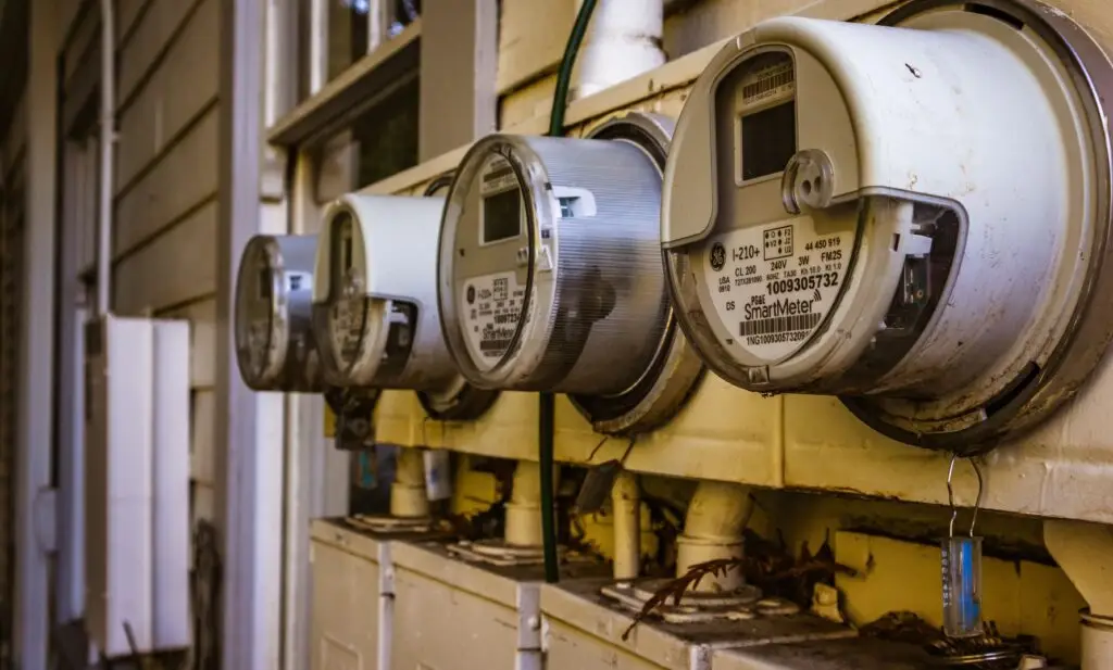 Training & Courses Image of multiple smart electricity meters installed on a residential exterior wall, showing environmental adaptation.