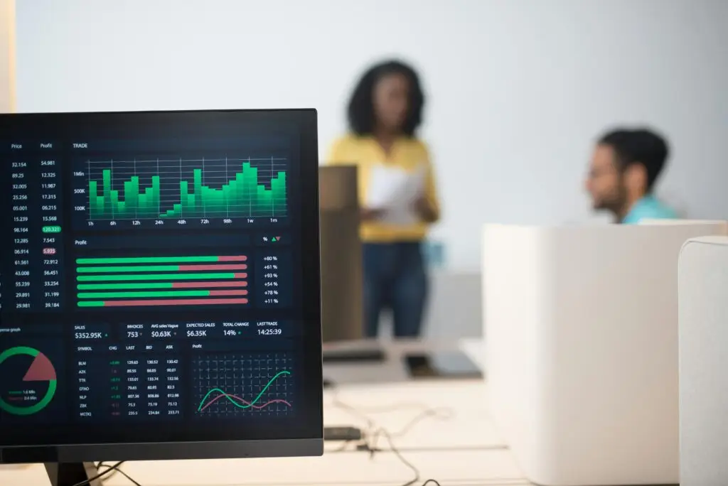 Training & Courses Modern office with financial trading screens and a diverse team discussing strategies.