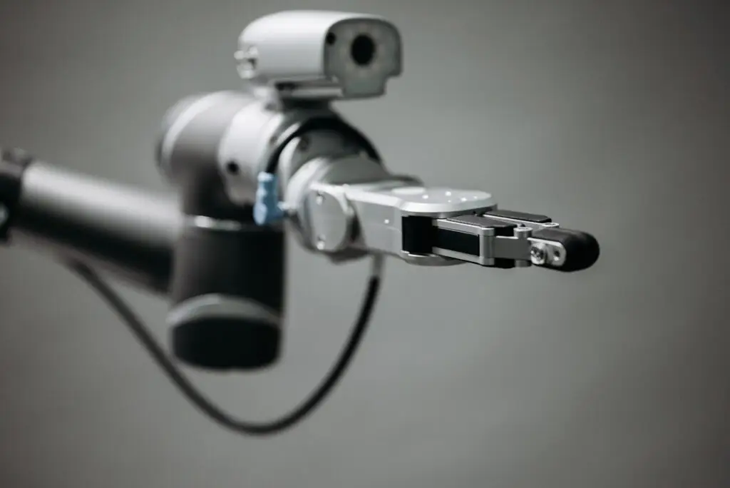 Training & Courses Close-up of a robotic arm showcasing advanced technology and innovation in an indoor environment.