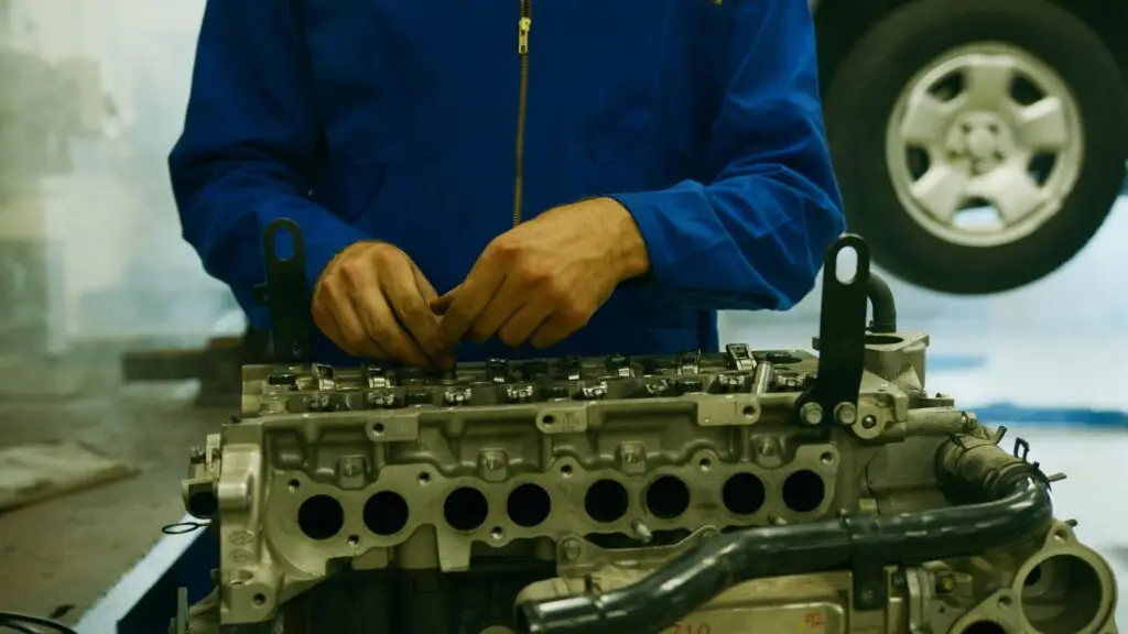 Training & Courses Close-up of a mechanic repairing an engine in a garage setting.